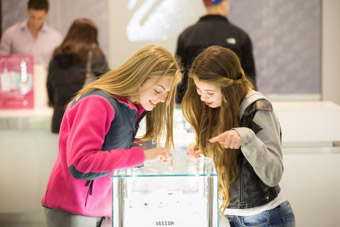 Girls at the mall looking at jewelry